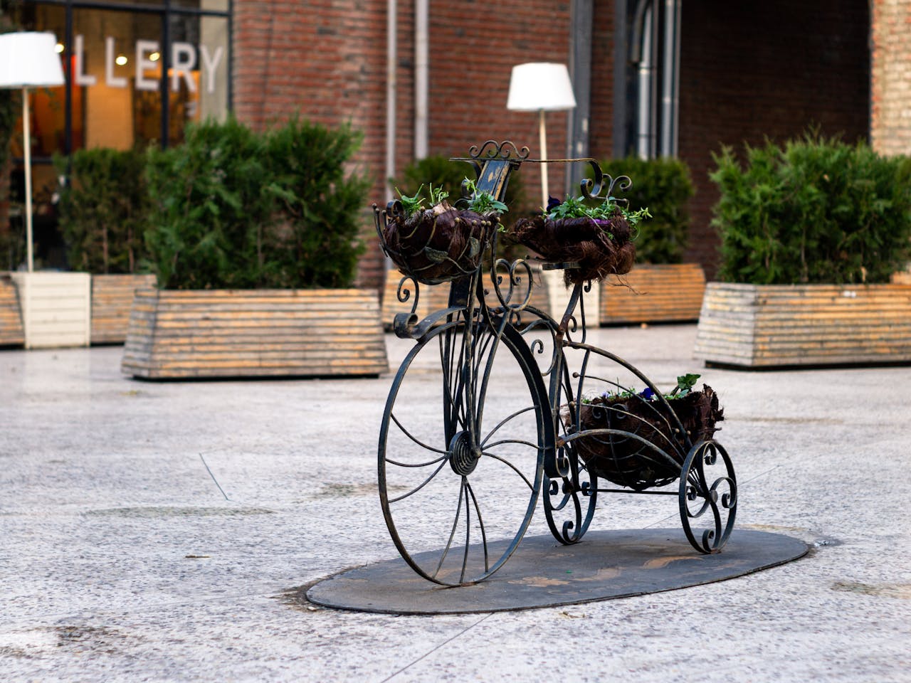 services-02 Artistic metal bike planter with flowers in an urban square, enhancing the public space decor.